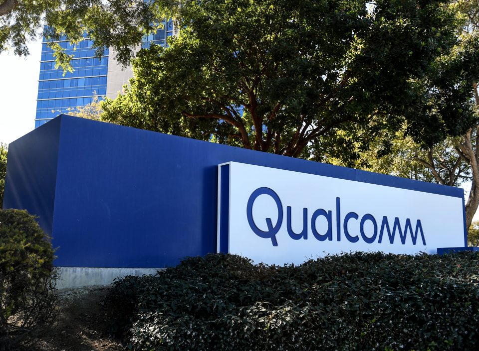 Η επιγραφή Qualcomm μπροστά από κτίριο της εταιρείας, ανάμεσα σε δέντρα
